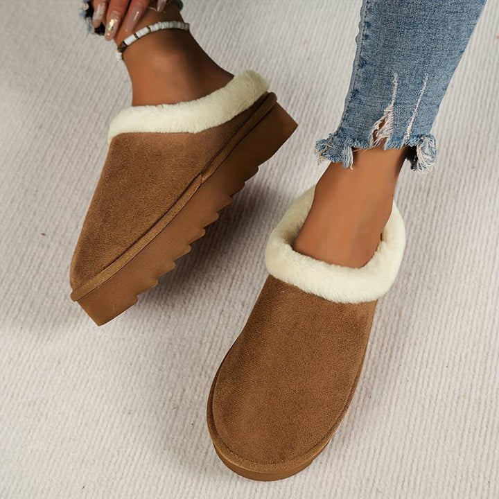 Lichtbruine damespantoffels met witte voering, suède look, comfortabele zool, perfect voor binnengebruik. Ideaal voor koude dagen, trendy en warm.