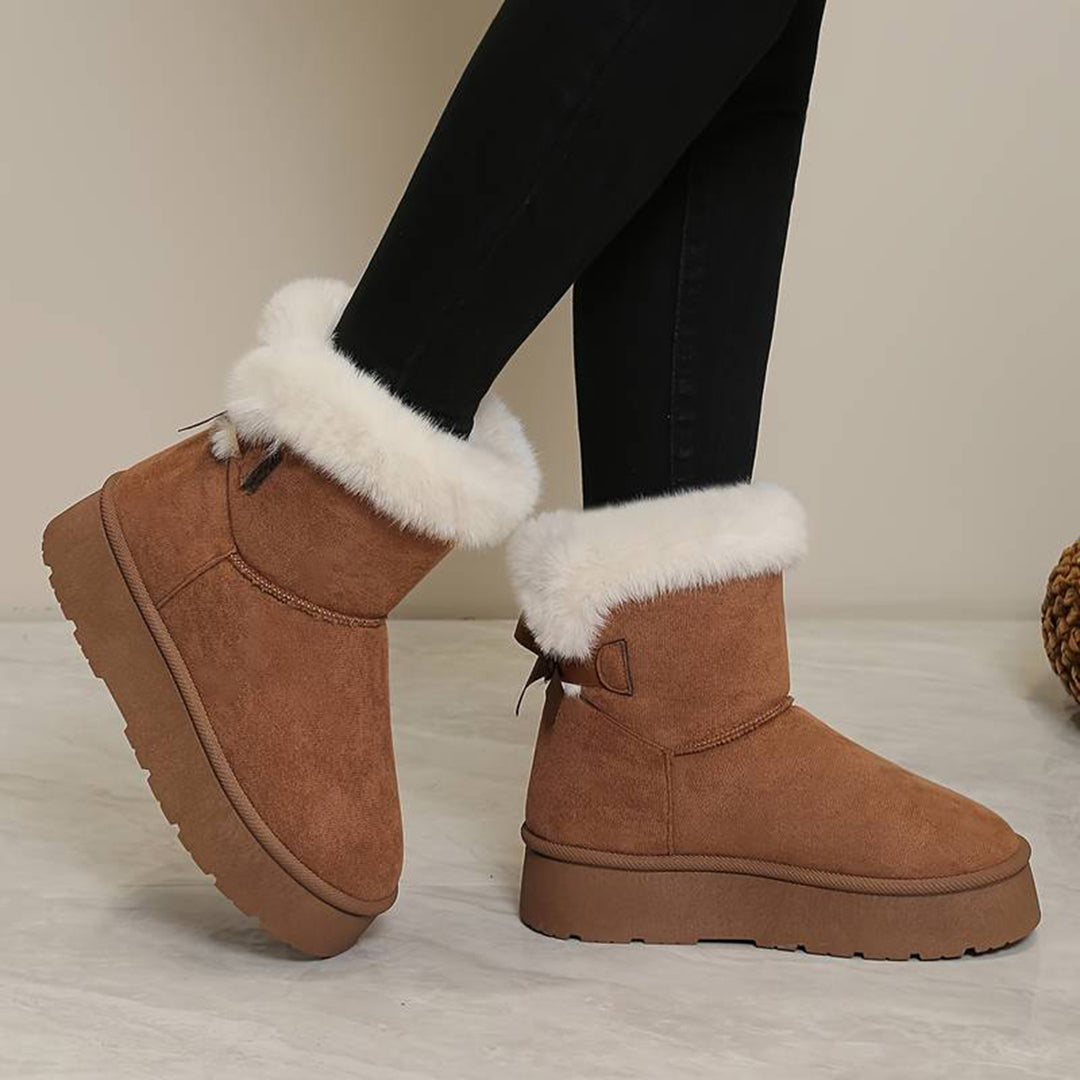 Lichtbruine suède laarzen met witte bontkraag, dikke zool en ritssluiting, gedragen door model. Perfect voor wintermode en casual outfits.