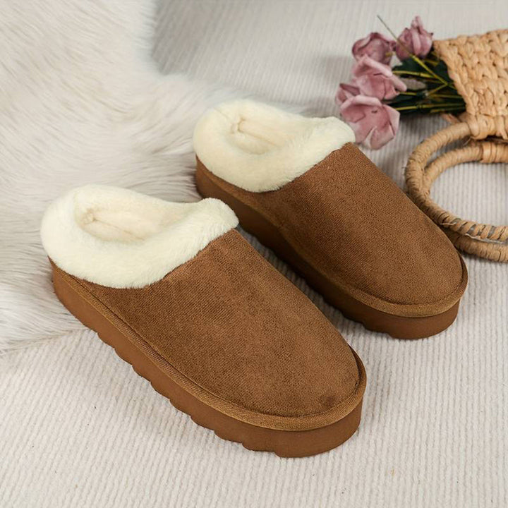 Lichtbruine pantoffels met witte voering, warme winter slippers, comfortabele huis schoenen, zachte zool, perfect voor koude dagen, naast bloemen.