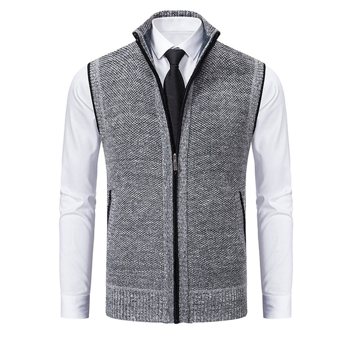 Grijze herenvest met ritssluiting, gedragen over een witte overhemd en zwarte stropdas. Stijlvolle, casual outfit voor kantoor of dagelijks gebruik.