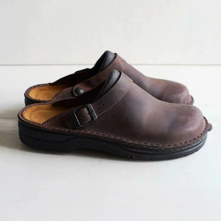 Bruine leren herenpantoffels met gesp, comfortabele zool, ideaal voor dagelijks gebruik. Stijlvolle en duurzame herenschoenen voor thuis.