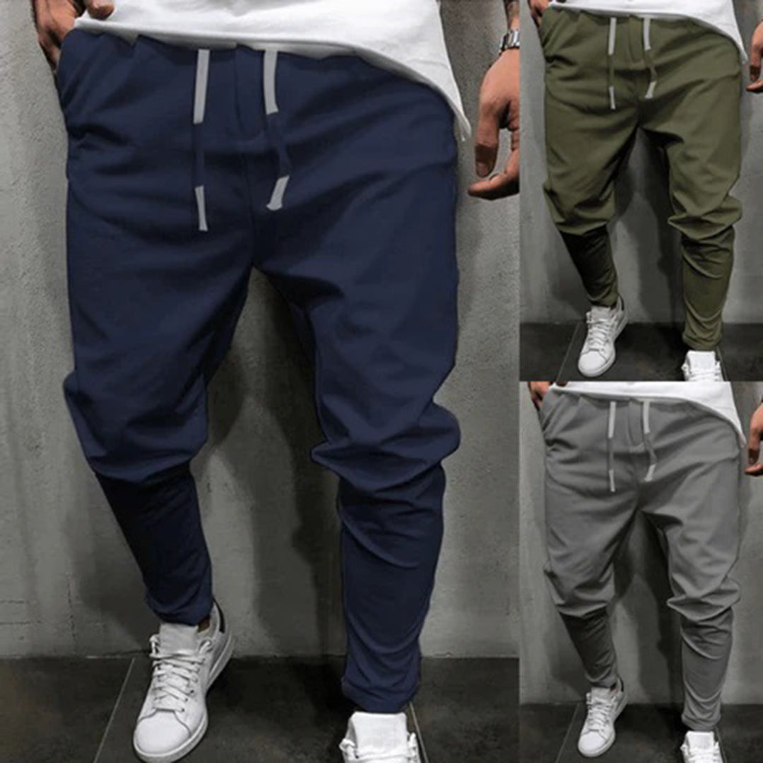 Drie heren joggingbroeken in blauw, groen en grijs, met elastische tailleband en trekkoord, ideaal voor casual en sportieve outfits.