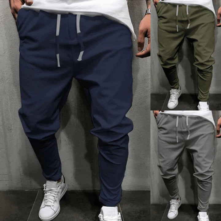 Drie heren joggingbroeken in blauw, groen en grijs, met elastische tailleband en trekkoord, ideaal voor casual en sportieve outfits.