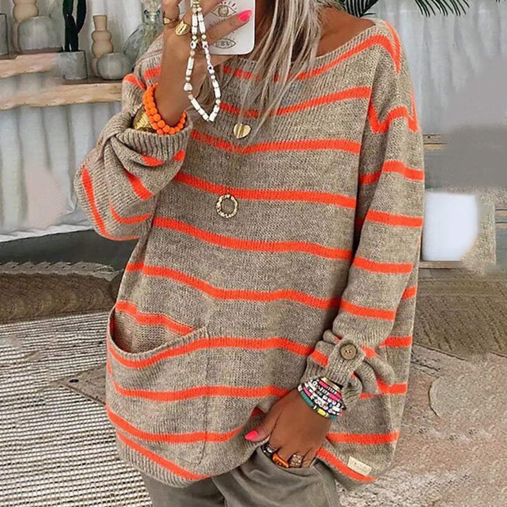 Vrouw in oversized gestreepte trui met oranje en beige strepen, sieraden en smartphone. Trendy herfstmode, casual stijl, comfortabele outfit.