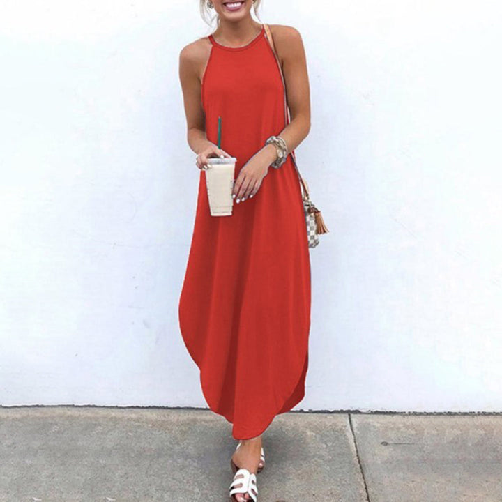 Vrouw in lange, mouwloze rode jurk met halternek, houdt een drankje vast. Zomerse outfit, casual stijl, witte sandalen, minimalistische achtergrond.