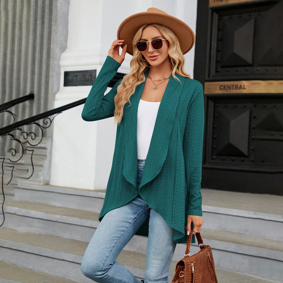 Vrouw in groene cardigan, jeans en hoed poseert buiten. Modieuze herfstoutfit, dameskleding, casual stijl, trendy accessoires.
