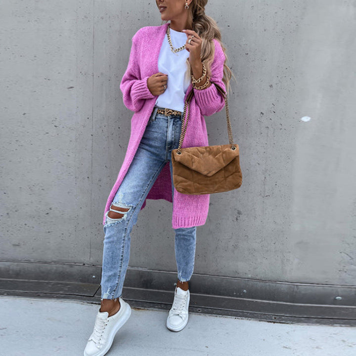 Vrouw in casual outfit met roze gebreid vest, gescheurde jeans en witte sneakers, draagt een bruine schoudertas. Trendy damesmode, streetwear stijl.