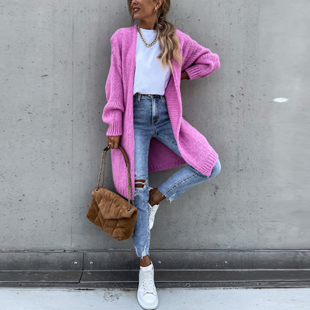 Vrouw in roze gebreid vest, witte top, gescheurde jeans en witte sneakers, met bruine tas. Modieuze casual outfit, trendy dameskleding.