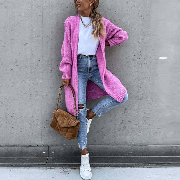Vrouw in roze gebreid vest, witte top, gescheurde jeans en witte sneakers, met bruine tas. Modieuze casual outfit, trendy dameskleding.