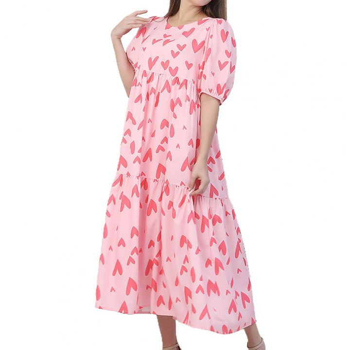 Roze maxi-jurk met hartjespatroon, korte mouwen en ronde hals. Perfect voor zomerse dagen. Trendy damesmode, comfortabele pasvorm.