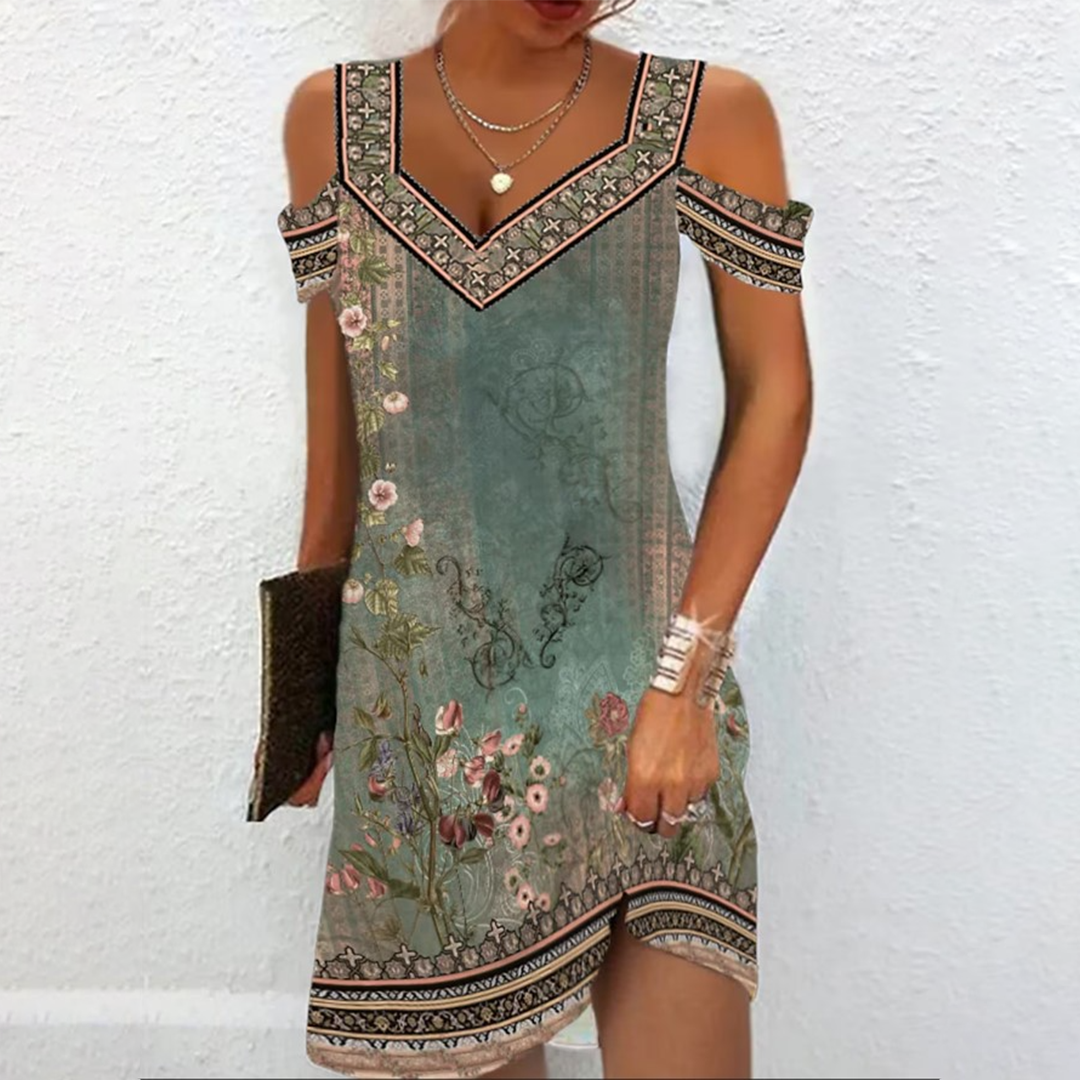 Vrouw in elegante zomerjurk met bloemenprint en V-hals, off-shoulder ontwerp, tegen witte achtergrond. Perfect voor casual en feestelijke gelegenheden.