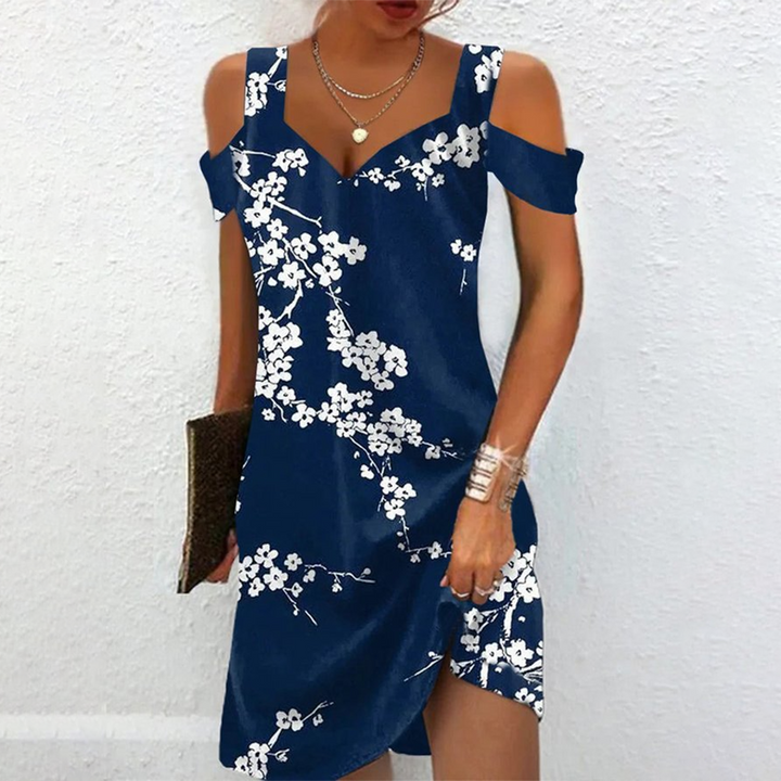 Blauwe zomerjurk met witte bloemenprint, off-shoulder ontwerp, ideaal voor casual en strandoutfits. Trendy damesmode, comfortabele pasvorm.
