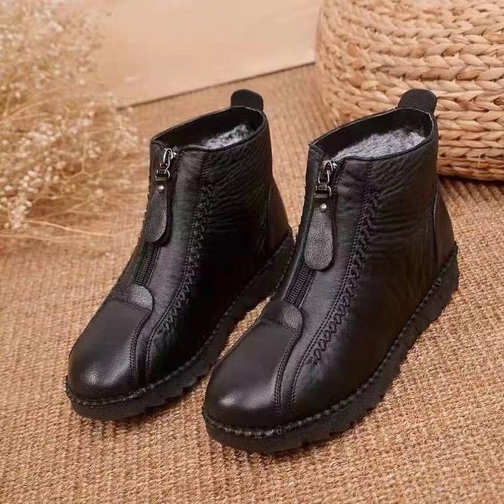 Zwarte leren enkellaarsjes met ritssluiting, warme voering en stevige zool, perfect voor wintermode en casual outfits. Comfortabele en stijlvolle schoenen.