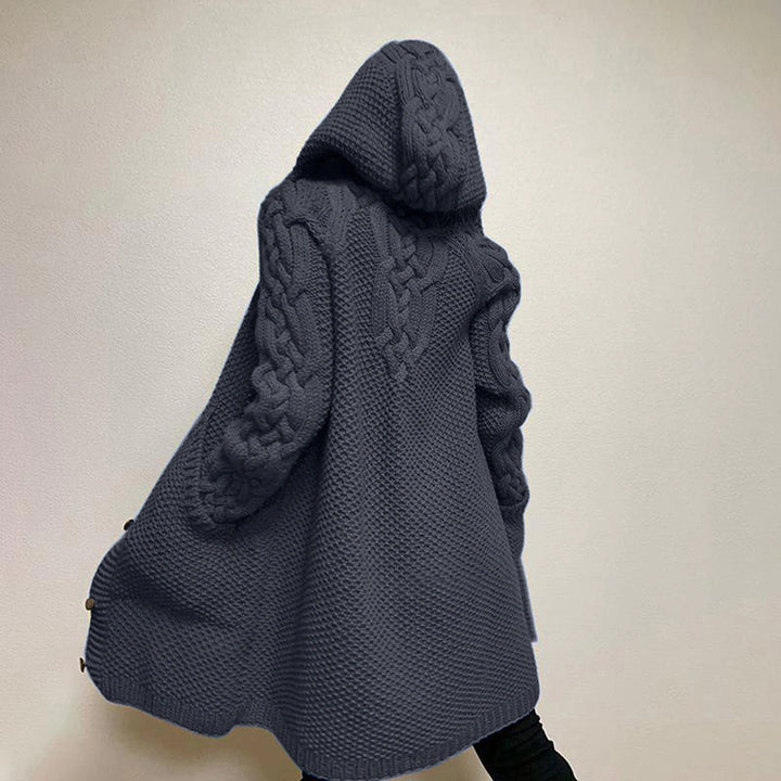 Grijze gebreide damestrui met capuchon, kabelpatroon en lange mouwen. Stijlvolle wintermode, warme oversized trui voor casual outfits.