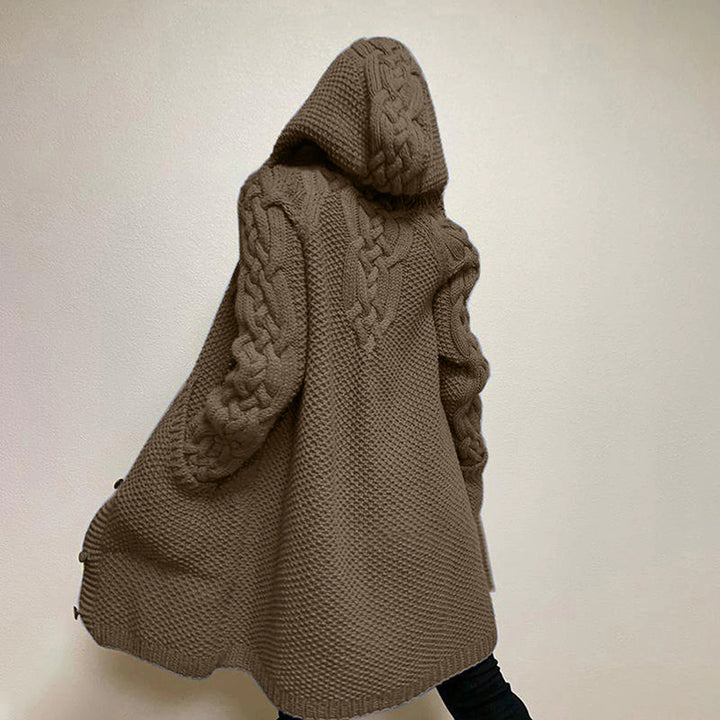 Bruine gebreide damestrui met capuchon en kabelpatroon, modieuze oversized stijl, ideaal voor herfst- en wintermode.
