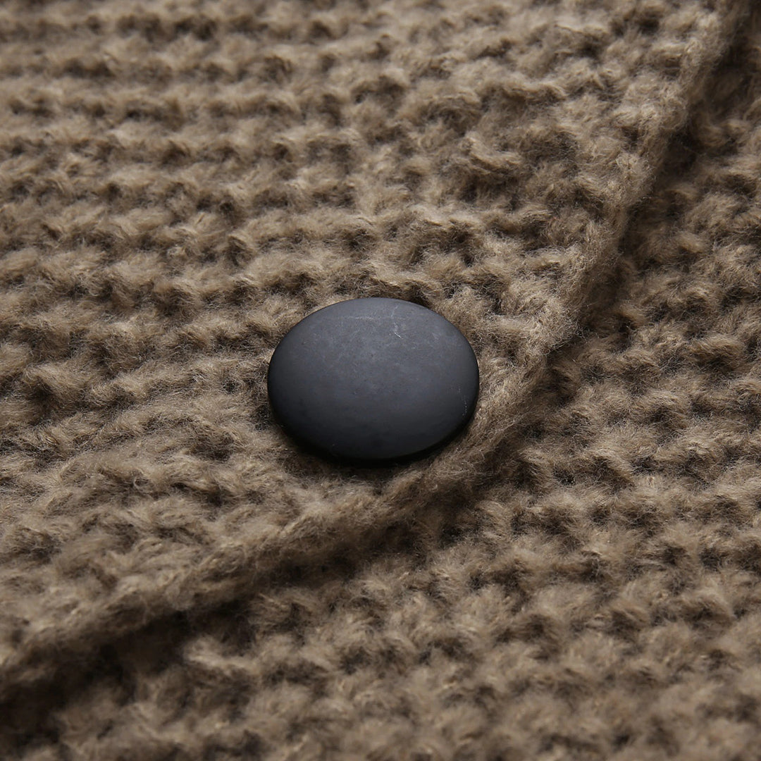 Bruine wollen jas met grove textuur en zwarte knoop, close-up. Stijlvolle wintermode, warme kleding, hoogwaardige materialen.