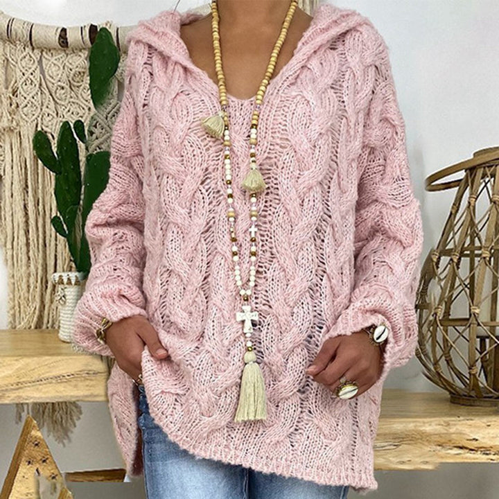 Roze gebreide trui met kabelpatroon, gedragen door model. Stijlvolle damesmode, casual winterkleding, comfortabele oversized pasvorm.