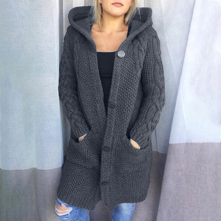 Grijze gebreide damesvest met capuchon, lange mouwen en zakken, ideaal voor herfst en winter. Comfortabel en stijlvol kledingstuk.