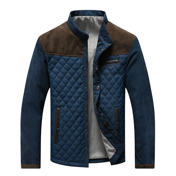 Blauwe gewatteerde herenjas met bruine schouderaccenten, ritssluiting en opstaande kraag. Stijlvolle winterjas voor heren.