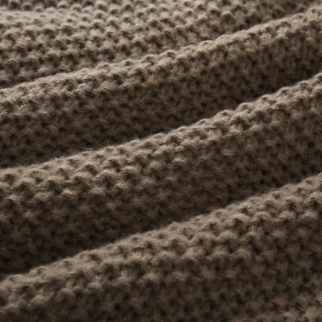 Bruine gebreide deken textuur, close-up. Zachte, warme wollen stof met geribbelde structuur. Perfect voor interieurdecoratie en comfort.