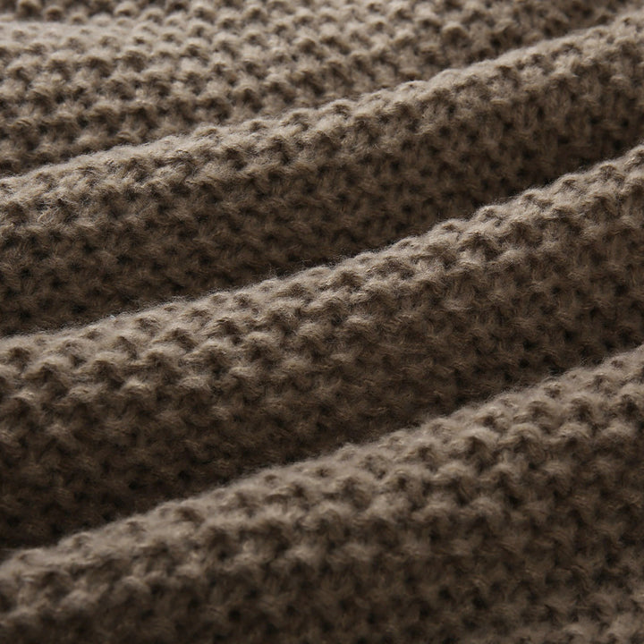 Bruine gebreide deken textuur, close-up. Zachte, warme wollen stof met geribbelde structuur. Perfect voor interieurdecoratie en comfort.