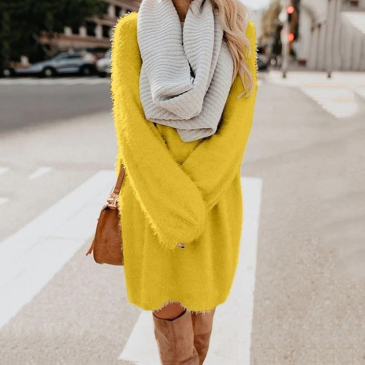 Vrouw in gele trui jurk met grijze sjaal en bruine laarzen op straat. Modieuze herfstoutfit, casual stijl, stedelijke achtergrond.