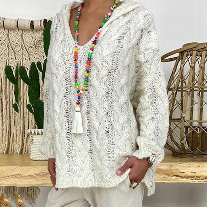 Witte gebreide trui met kabelpatroon, kleurrijke kralenketting, boho-stijl, casual damesmode, comfortabele herfstkleding, trendy en stijlvol design.