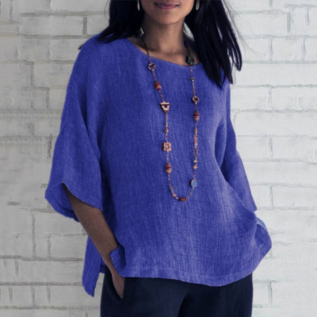 Blauwe linnen blouse voor dames, driekwart mouwen, casual stijl, gecombineerd met lange ketting. Perfect voor lente- en zomermode.