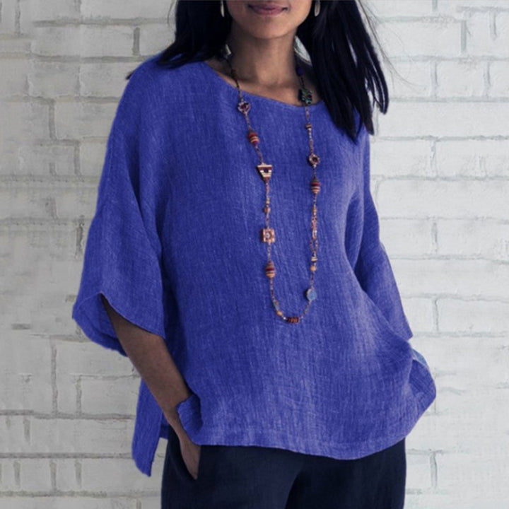 Blauwe linnen blouse voor dames, driekwart mouwen, casual stijl, gecombineerd met lange ketting. Perfect voor lente- en zomermode.