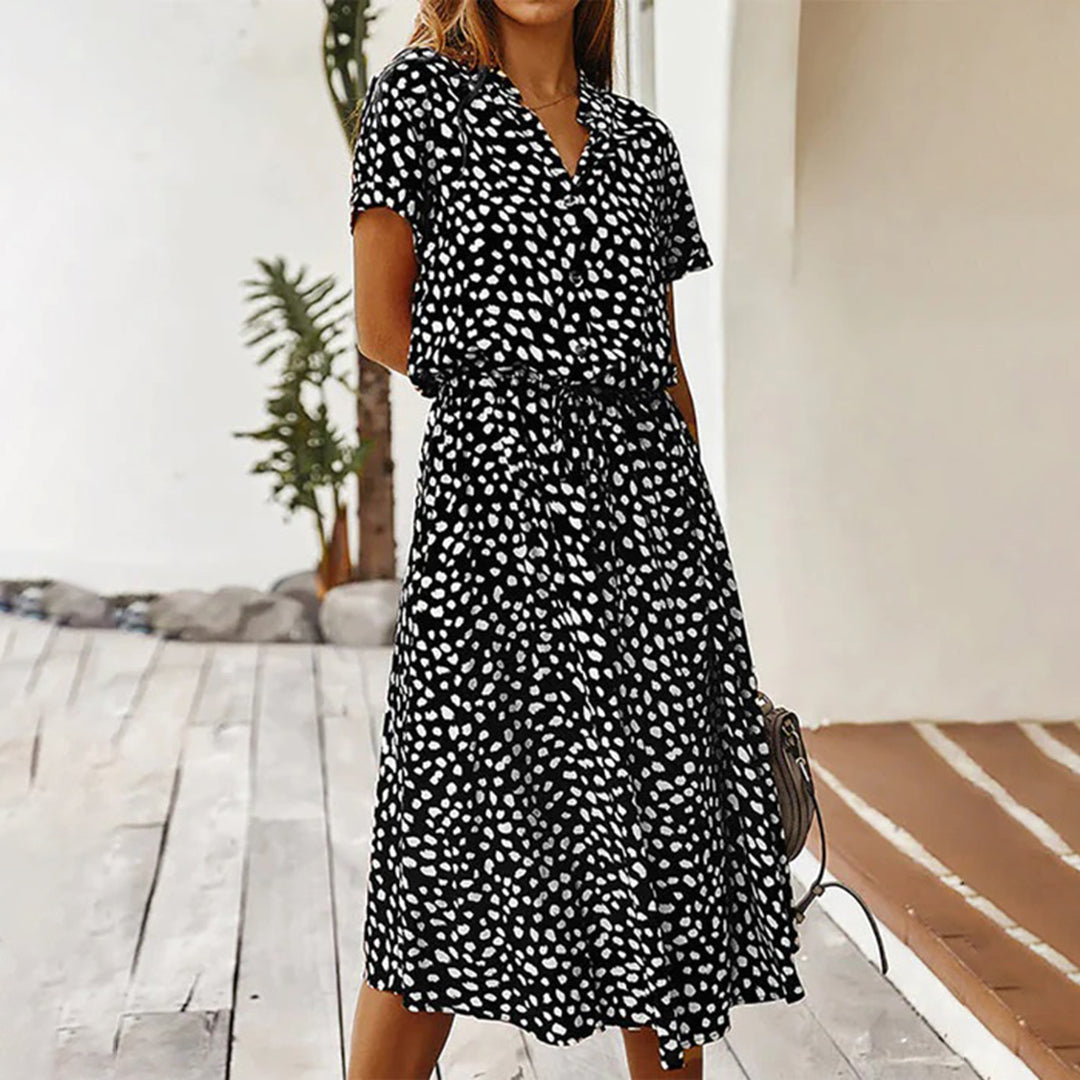 Zwart-witte stippenjurk voor dames, korte mouwen, knoopsluiting, casual zomeroutfit, modieuze dameskleding, comfortabele pasvorm.