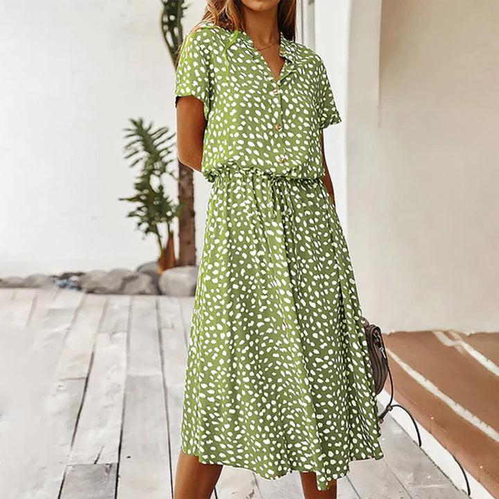 Groene zomerjurk met witte stippen, korte mouwen en knoopsluiting. Perfect voor casual en elegante zomerse outfits. Vrouwelijke mode, trendy design.