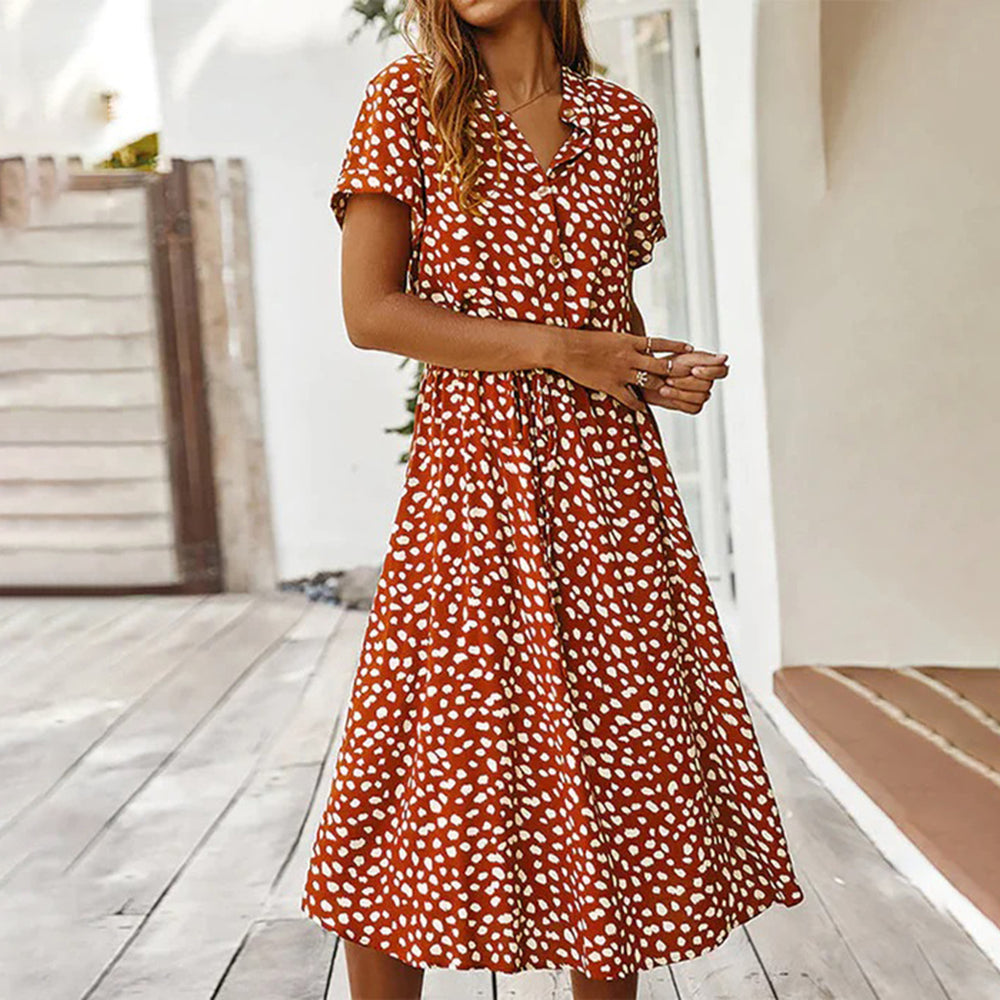 Vrouw in rood-witte stippenjurk, zomerkleding, casual mode, korte mouwen, knielengte, buitenomgeving, trendy dameskleding.