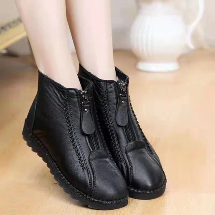 Zwarte leren enkellaarsjes met ritssluiting, comfortabele platte zool, geschikt voor dames. Modieuze en veelzijdige schoenen voor dagelijks gebruik.
