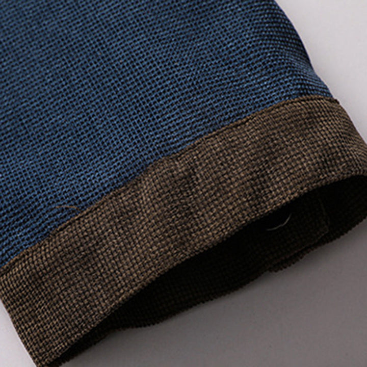 Blauwe en bruine gebreide trui mouw, close-up. Hoogwaardige herenkleding, casual stijl, comfortabele stof, modieuze winterkleding.