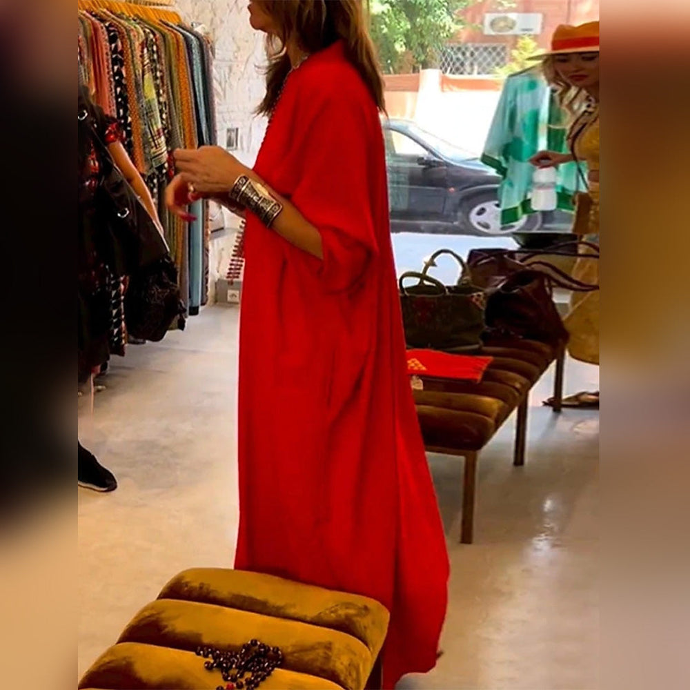 Vrouw in felrode jurk in boetiek, omringd door kleurrijke kledingrekken. Mode, winkel, dameskleding, trendy, stijlvol, boetiek.