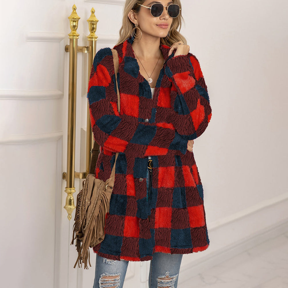 Vrouw in rood-zwart geruite jas, met zonnebril en bruine franjerugtas, poseert in lichte ruimte. Modieuze winterkleding, casual stijl.