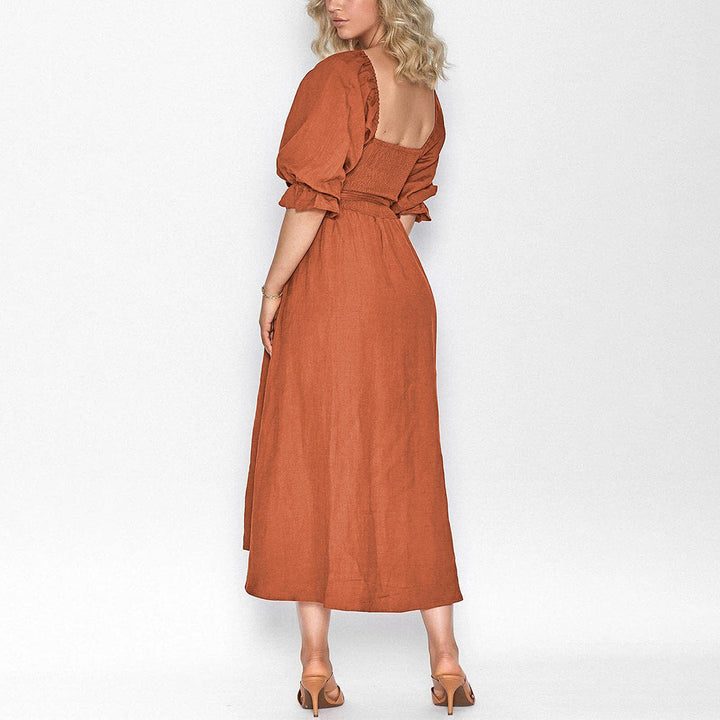 Vrouw in elegante, lange, terracotta jurk met pofmouwen en open rug. Perfect voor zomer- of avondkleding. Modieuze dameskleding.
