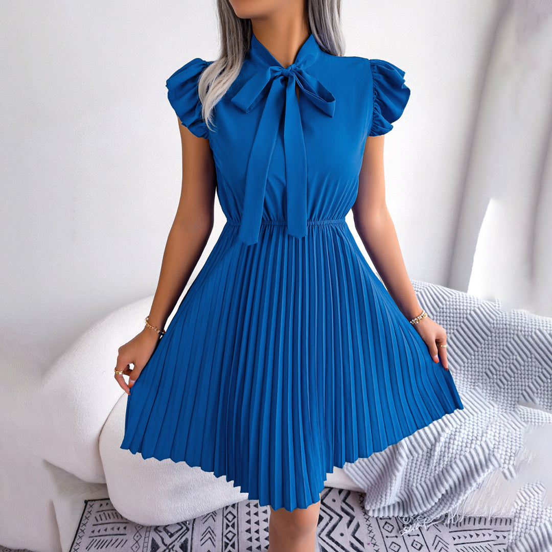 Koningsblauwe geplooide jurk met strik, korte mouwen en elegante uitstraling. Perfect voor zomerse evenementen en modieuze gelegenheden.
