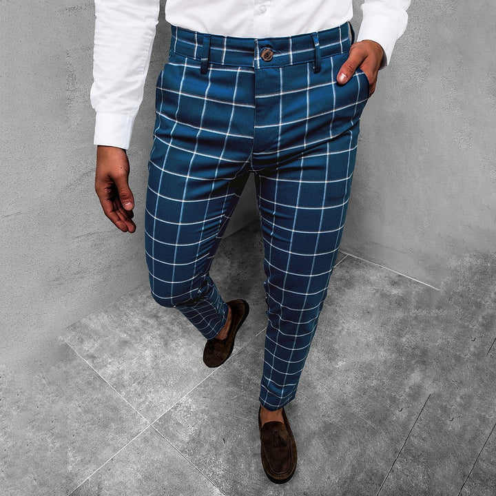 Man in blauwe geruite broek en witte overhemd, stijlvolle herenkleding, mode, casual outfit, trendy design, moderne stijl, bruine schoenen.