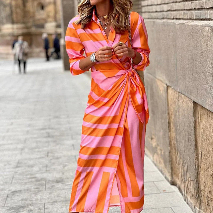 Stijlvolle zomerjurk met roze en oranje strepen, lange mouwen en knoopdetail, perfect voor modieuze zomerdagen. Vrouwelijke mode, trendy jurk.