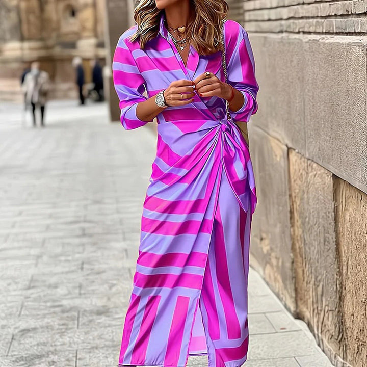 Stijlvolle zomerjurk met roze en paarse strepen, driekwart mouwen en geplooid detail, ideaal voor modieuze zomerdagen in de stad.
