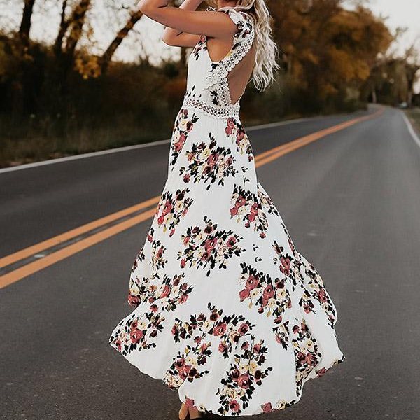 Vrouw in witte bloemenjurk op lege weg, herfstachtergrond, bohemian stijl, open rug, vloeiende stof, modetrend, casual elegantie.