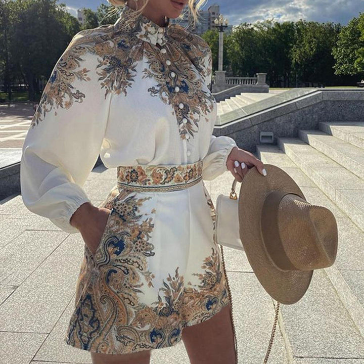 Vrouw in elegante witte jurk met barokke print, holding een strohoed, buiten op zonnige dag. Mode, zomerjurk, dameskleding, stijlvolle outfit.