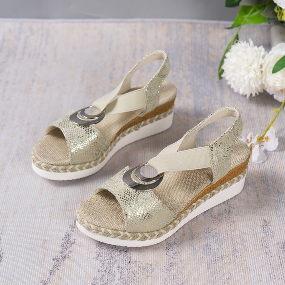 Witte dames sandalen met sleehak, gevlochten zool en metallic bandjes. Perfect voor zomerse outfits. Comfortabele en stijlvolle schoenen.