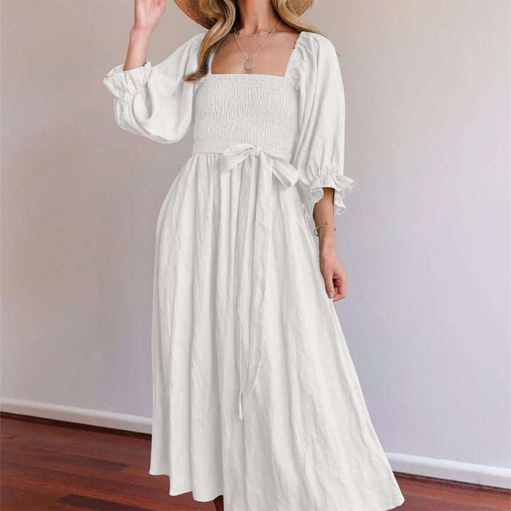 Witte zomerjurk met pofmouwen en strikceintuur, elegante damesmode, casual en stijlvol, perfect voor warme dagen.
