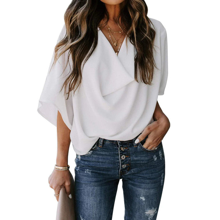 Vrouw in witte blouse met draperie, gecombineerd met blauwe jeans. Modieuze dameskleding, casual stijl, trendy outfit voor dagelijks gebruik.