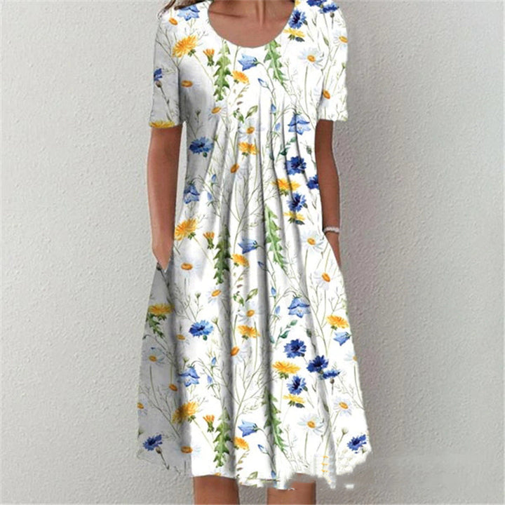 Witte zomerjurk met korte mouwen en kleurrijke bloemenprint, ideaal voor casual damesmode. Comfortabele pasvorm, perfect voor warme dagen.