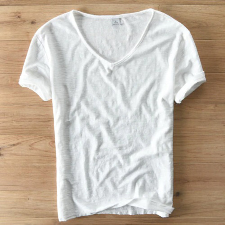 Witte katoenen T-shirt met V-hals op houten vloer, casual kleding, comfortabele pasvorm, perfect voor dagelijks gebruik, unisex mode.