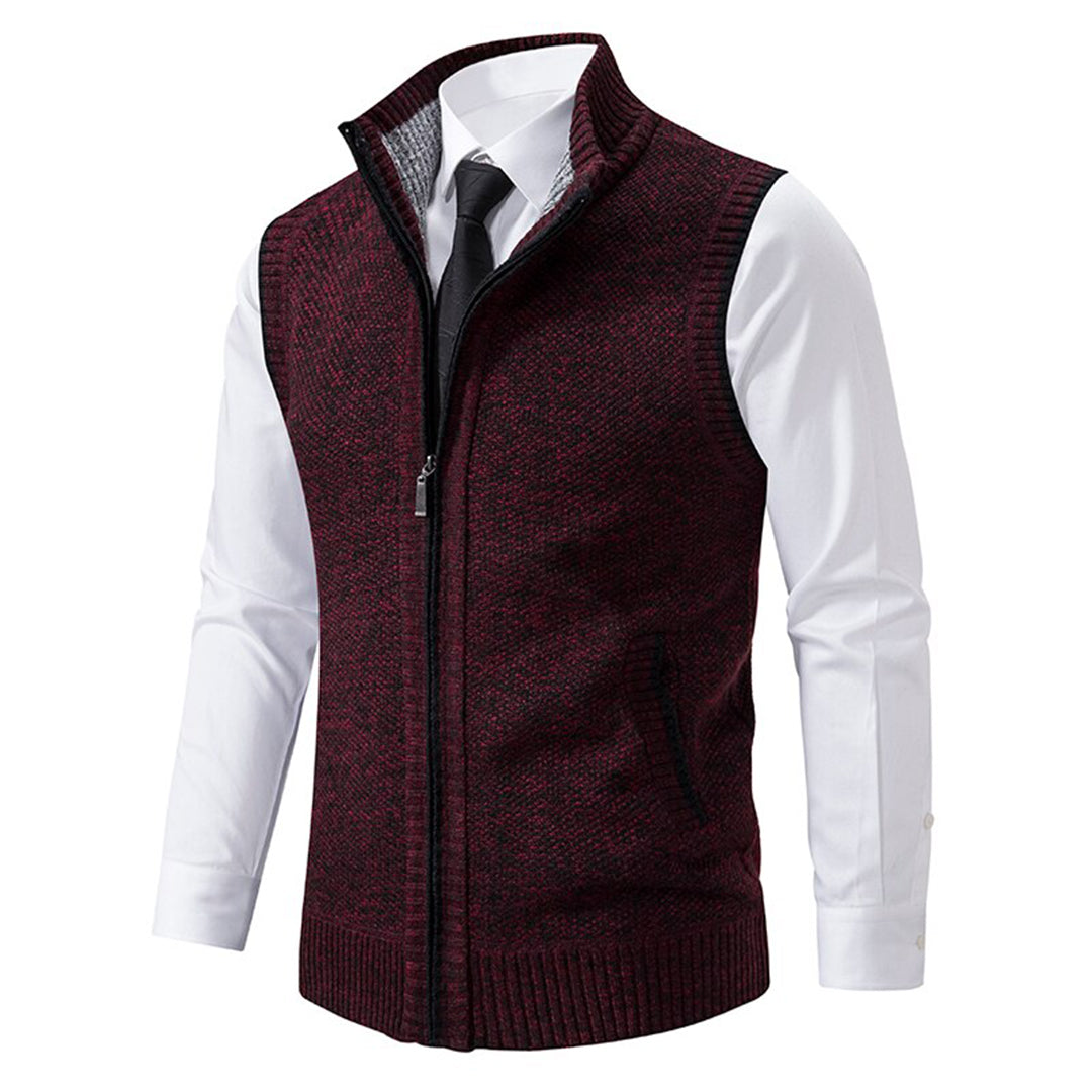 Bordeauxrode herenvest met ritssluiting, gedragen over een witte overhemd en zwarte stropdas. Stijlvolle, warme kleding voor herfst en winter.