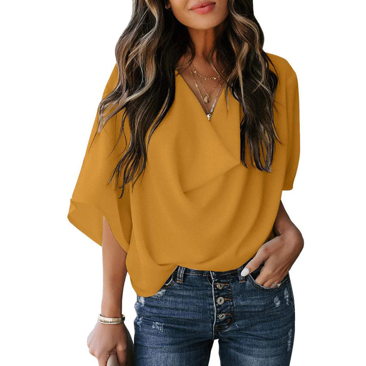 Vrouw in gele blouse met V-hals en korte mouwen, gecombineerd met blauwe jeans. Modieuze dameskleding, casual stijl, trendy outfit.